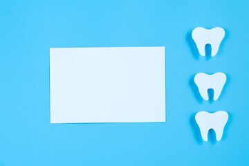 Paper cut mockup of tooth on blue background. Dental care concept. International Dentist Day.