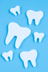 Paper cut mockup of tooth on blue background. Dental care concept. International Dentist Day.