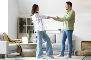 Fototapeta premium Happy young couple dancing at home