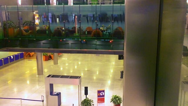 December 24, 2020 - Charles de Gaulle Airport, Paris, France. High angle view of a man walking across an empty corridor in the airside transfer waiting area.