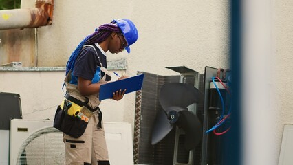 Capable electrician servicing external air conditioner internal components, checking freon level...