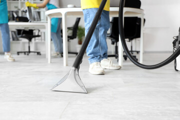 Male janitor cleaning floor in office, closeup