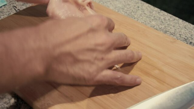 March 3, 2024 - Toronto, Ontario Canada. Close up demonstration of removing the chicken skin from the breast meat.