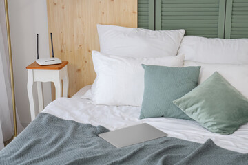 Modern wi-fi router on bedside table in room