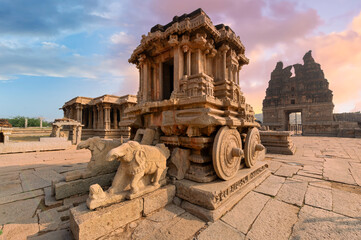 Famous ancient stone chariot of Hampi in closeup view with other architecture ruins at Karnataka,...