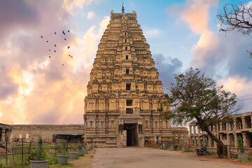 Historic Virupaksha Temple with ancient stone carvings at Hampi, Karnataka, India, with moody sunset sky