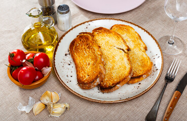 Preparation of appetizing Catalan tapas Pan con tomate - grilled bread topped with mixture of...