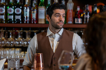Man bartender is making a drink and dancing at bar. Dance party with group people dancing . Women and men have fun and drinking martini cocktail in night club.