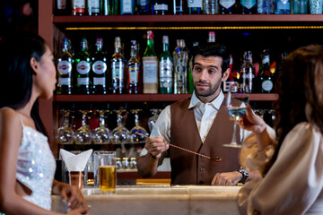 two girls in sexy dress are drinking and dancing at bar. Dance party with group people dancing . Women and men have fun and drinking martini cocktail in night club.