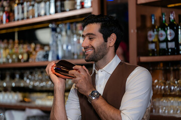 Man bartender is making a drink and dancing at bar. Dance party with group people dancing . Women and men have fun and drinking martini cocktail in night club.