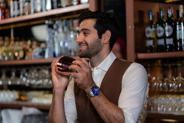 Man bartender is making a drink and dancing at bar. Dance party with group people dancing . Women and men have fun and drinking martini cocktail in night club.