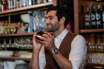 Man bartender is making a drink and dancing at bar. Dance party with group people dancing . Women and men have fun and drinking martini cocktail in night club.