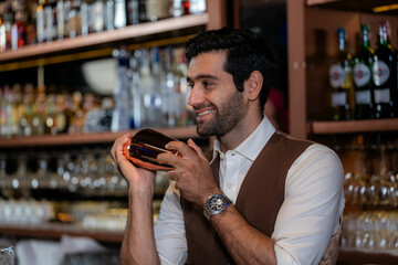Man bartender is making a drink and dancing at bar. Dance party with group people dancing . Women and men have fun and drinking martini cocktail in night club.