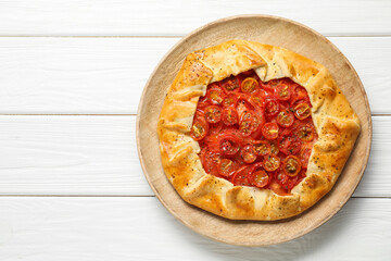 Tasty tomato galette (Caprese galette) on white wooden table, top view. Space for text