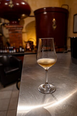 Tasting of cognac spirit aged in old French oak barrels in cellar in distillery in Cognac white wine region, Charente, Segonzac, Grand Champagne, France