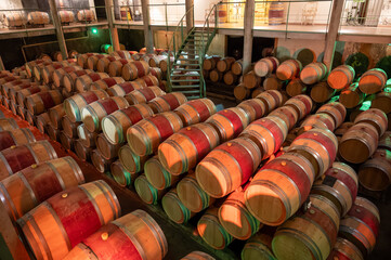 French oak wooden barrels for aging red wine in underground cellar, Saint-Emilion wine making...