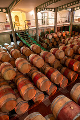 Fototapeta premium French oak wooden barrels for aging red wine in underground cellar, Saint-Emilion wine making region picking, cru class Merlot or Cabernet Sauvignon red wine grapes, France, Bordeaux