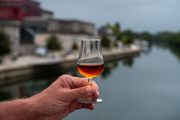 Tasting of cognac alcohol drink and view on old streets and houses in town Cognac, Grand Champagne,...