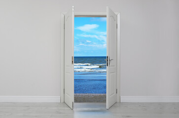Open door in white wall inviting to visit beach