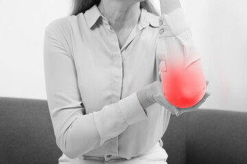 Woman suffering from rheumatism at home, closeup. Black and white effect with red accent in painful...