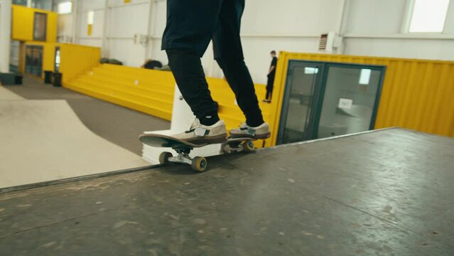 Young skater performing trick, skateboarder training in skatepark, making tricks, slides and flips, jump over the gap, professional extreme sport athlete ride on skateboard. 