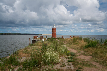 Fototapeta na wymiar Lighthouse in the village of Rybachy on a sunny summer day, Curonian Spit, Kaliningrad region, Russia