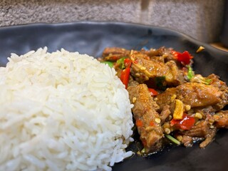 Pad Kra Pao Beef, Stir-fried Beef with Holy Basil, The dish is presented in a dark-colored bowl a local restaurant in Bangkok, Thailand