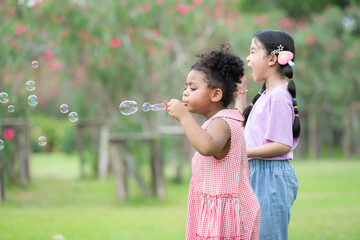 Girls in the park with blowing air bubble, Surrounded by greenery and nature