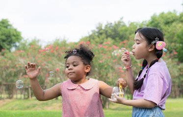 Girls in the park with blowing air bubble, Surrounded by greenery and nature
