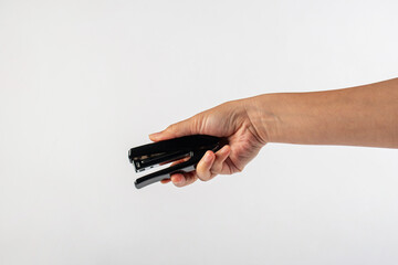 Black stapler in hand isolated on white background