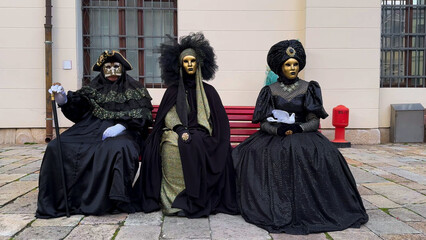 Venice Carnival. People in Venetian carnival masks and costumes on streets of Venice, Italy, Europe...