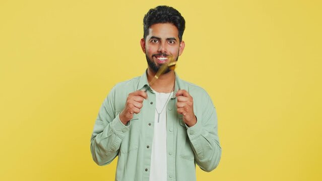 Ready to eat. Hungry Indian man waiting for serving dinner dishes with with restlessness holding cutlery fork knife will appreciate delicious restaurant meal. Excited guy isolated on yellow background