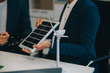 Fototapeta premium Two Young Engineers Expertise in Solar Cell Installation Meetings and Discussion in The Job. Planning to Install Solar Photovoltaic Panels on Roof Top in The Office Room with Factory Building Plan.