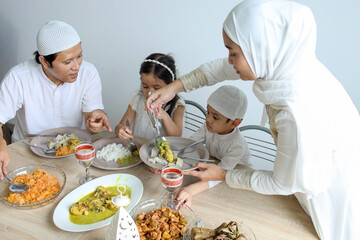 Fototapeta na wymiar Family enjoying special food at dining room during Eid Mubarak moment.