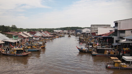 Fishing village with fishing boats parked along the wide river