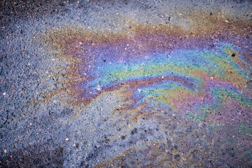 Textured stain of fuel or oil on wet asphalt on a rainy day. The concept of environmental pollution