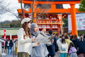 Travel, muslim, Two Asian female tourists of different religions friends visitor learning about...