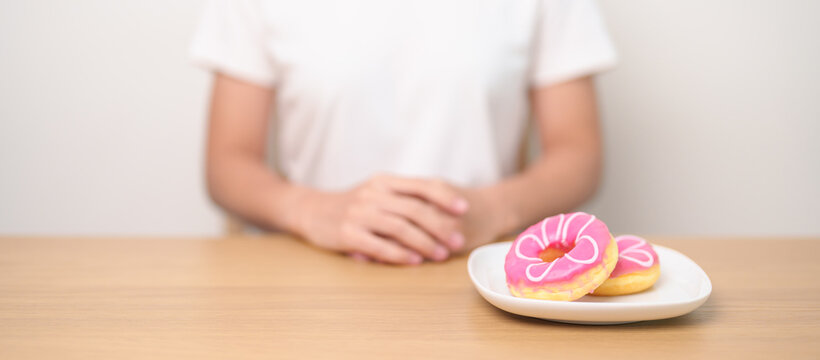 woman hand reject donut dessert, female refuse Unhealthy junk food. Dieting control, Weight loss, Obesity, eating lifestyle and nutrition concepts