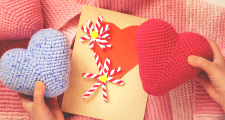Hands with crochet hearts and craft handmade greeting card with paper flowers. Hobby and happy...
