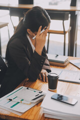 Asian women are stressed while working on laptop, Tired asian businesswoman with headache at office, feeling sick at work, copy space