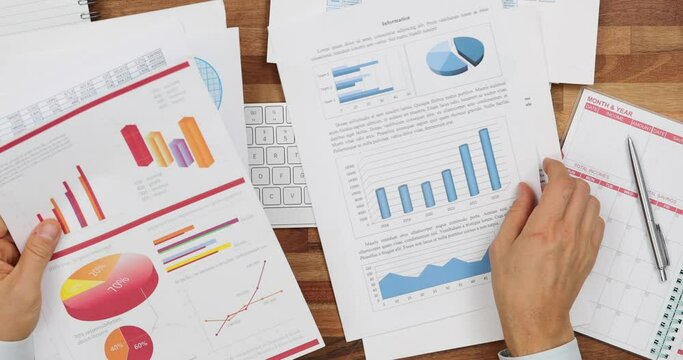 Businessman prepares reports with graphs and diagrams of documents for financing in office
