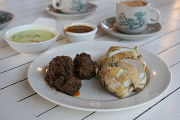 Traditional food in Malaysia known as Ketupat. It is rice cooked in woven coconut leaves, and served with rendang, chicken curry, lodeh and spicy peanut sauce.