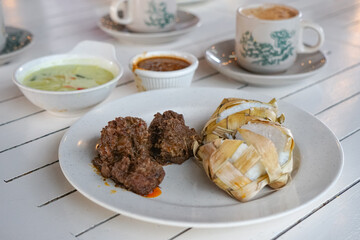 Traditional food in Malaysia known as Ketupat. It is rice cooked in woven coconut leaves, and served with rendang, chicken curry, lodeh and spicy peanut sauce.