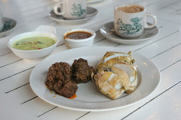 Traditional food in Malaysia known as Ketupat. It is rice cooked in woven coconut leaves, and served with rendang, chicken curry, lodeh and spicy peanut sauce.