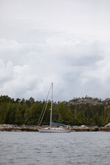 A beautiful sailboat in a remote anchorage with mountains in the background, Central coast of...