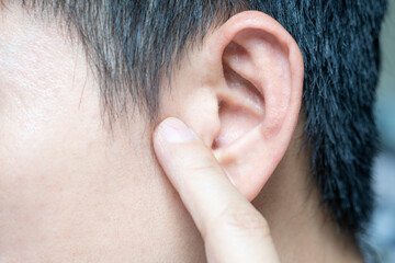 The young man touched his ear and he felt pain and his hearing was abnormal.