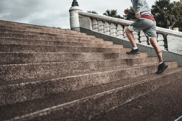 A man  running up on stairs in the city center park before cardio workout.  Health and Lifestyle in...