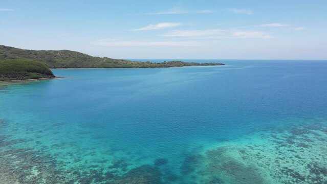 Coral reefs in the Yasawa Islands visible from the air. The reefs contribute to the vibrant colors of the water, ranging from light blues and greens in the shallows to deeper blues in the open ocean.