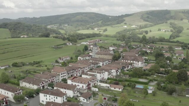 Ainhoa village and countryside landscape in Pyrenees Atlantiques, Nouvelle Aquitaine, France. Aerial backward
