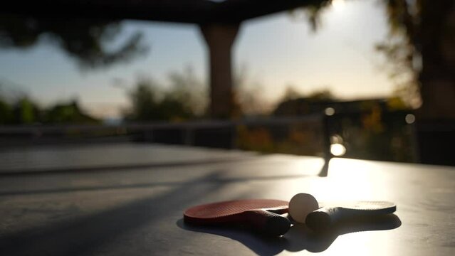 Ping pong table with paddles located on a terrace in Cannes France with sun shining, Close up handheld shot
